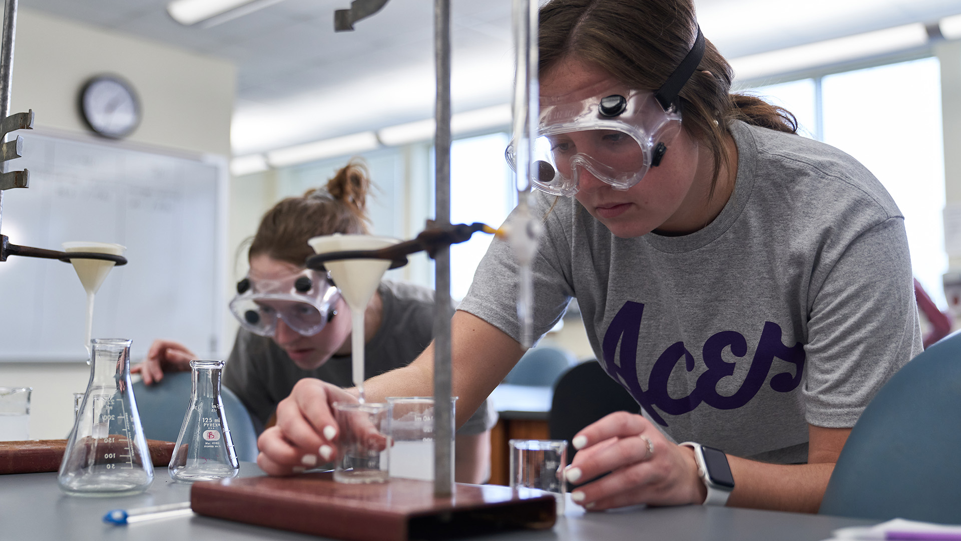 Chemistry students with flasks in lab