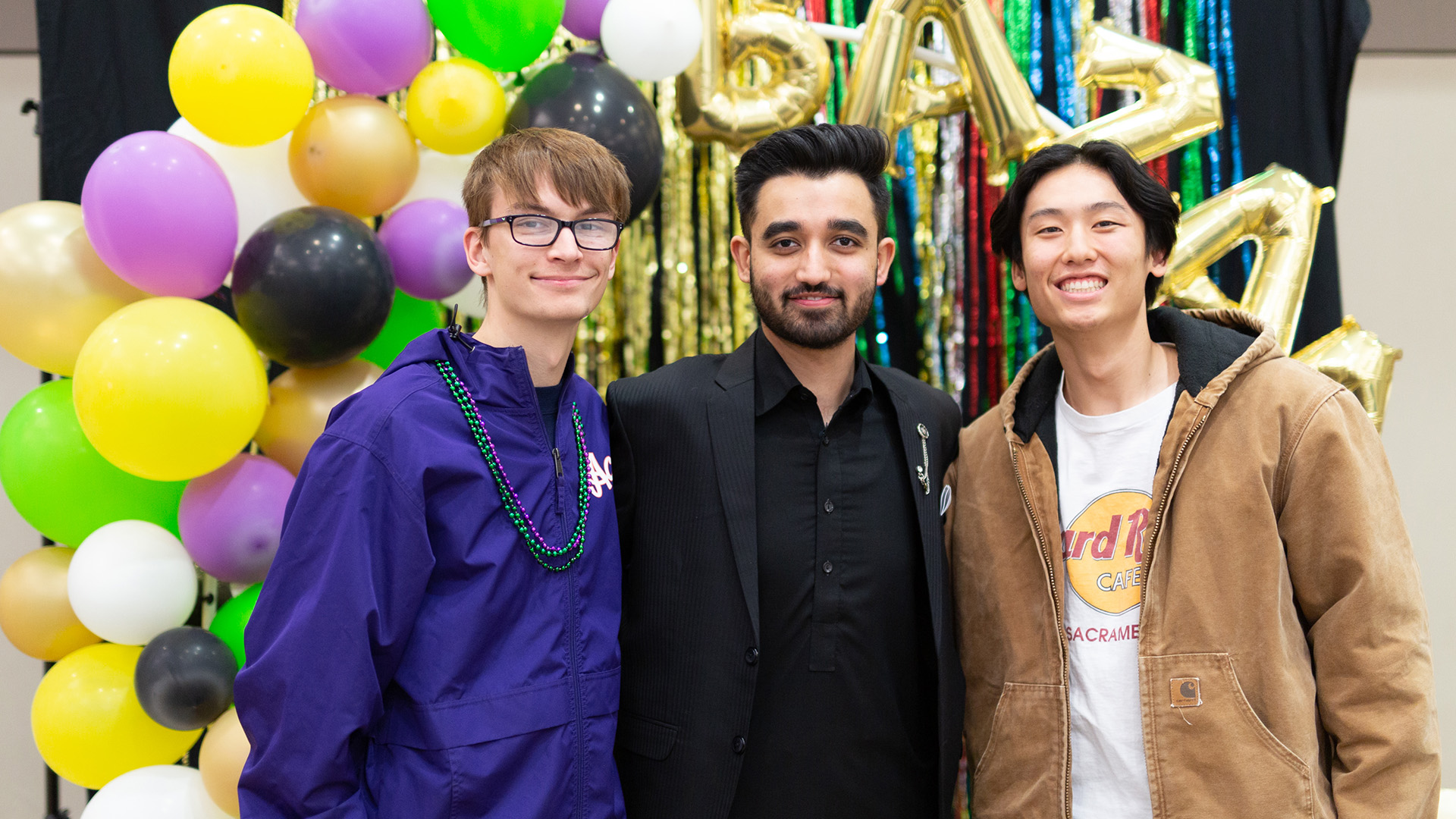 International Club members standing in front of balloons.