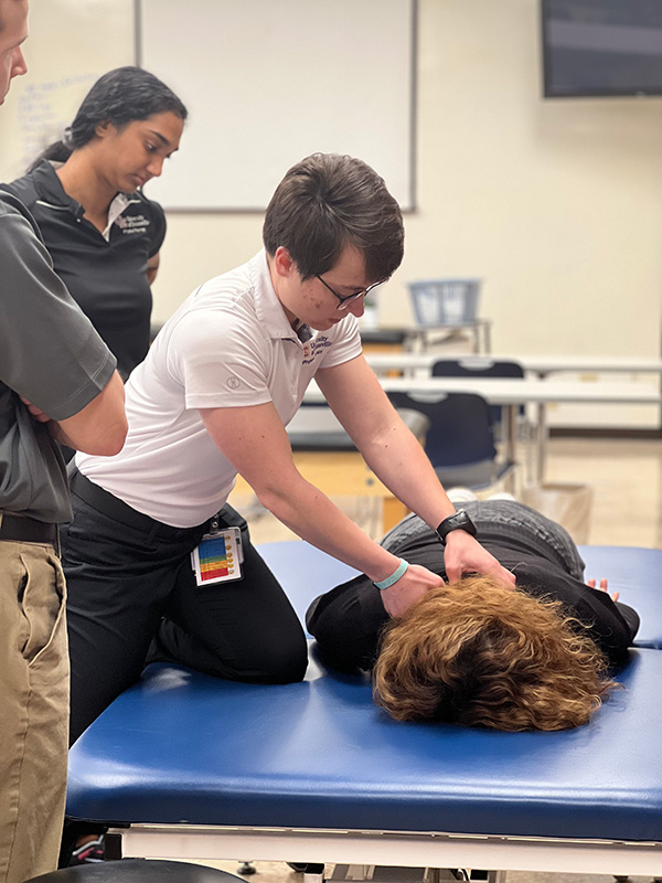 Ace PT student pressing neck of patient